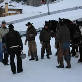 group of men with horses in snow